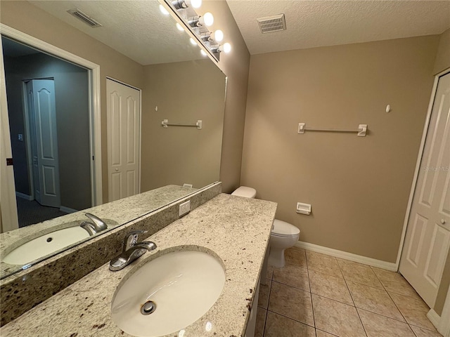 bathroom with visible vents, baseboards, vanity, and tile patterned flooring