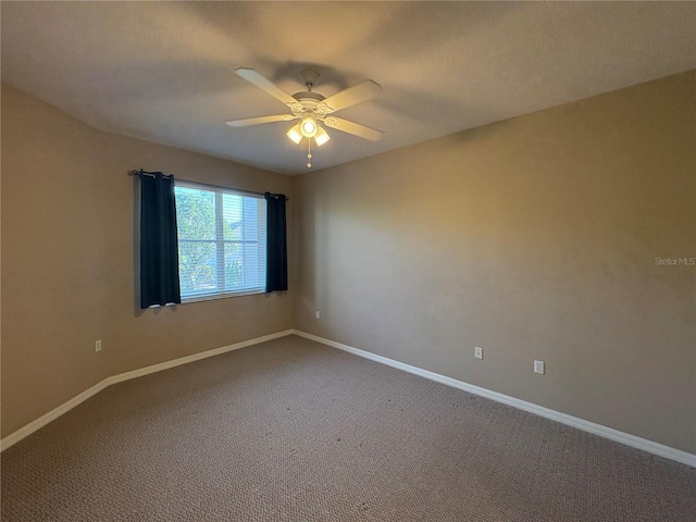 unfurnished room featuring carpet, baseboards, and a ceiling fan