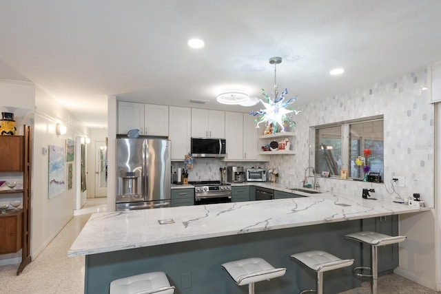 2207 Hickory Ave, Sarasota, FL 34234 - kitchen featuring stainless steel appliances, a sink, light stone countertops, baseboards, and recessed lighting