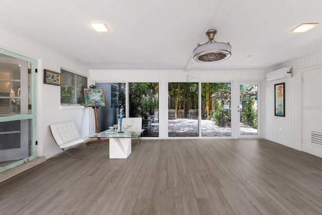2207 Hickory Ave, Sarasota, FL 34234 - unfurnished sunroom featuring wood finished floors and a wall mounted air conditioner