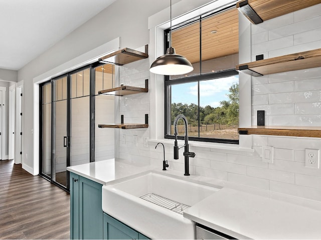 kitchen featuring a sink, open shelves, light countertops, and tasteful backsplash