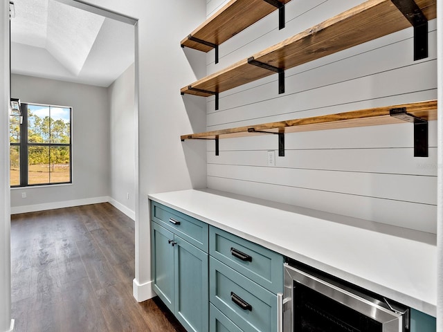 bar with wine cooler, baseboards, and dark wood finished floors