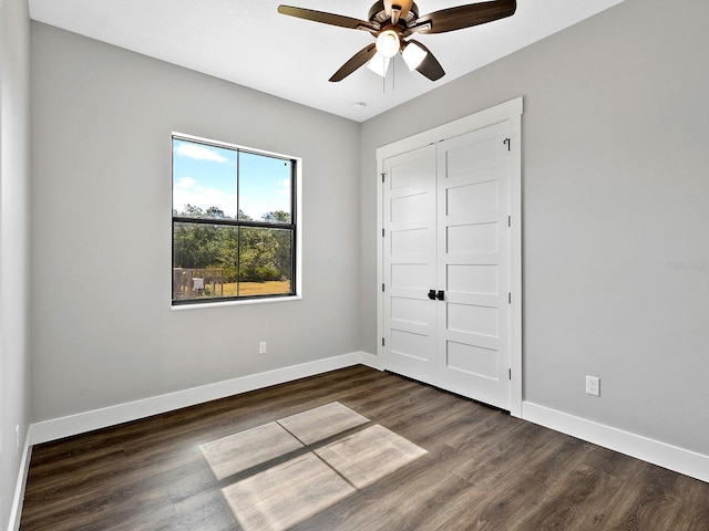 unfurnished bedroom featuring ceiling fan, baseboards, and wood finished floors