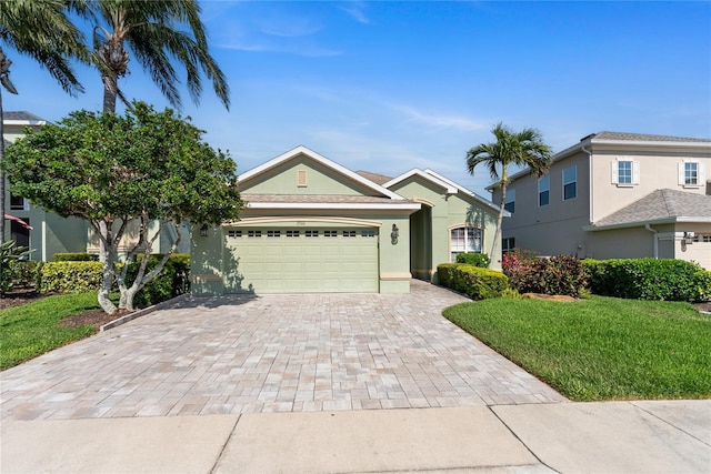 view of front facade with decorative driveway, a garage, a front yard, and stucco siding