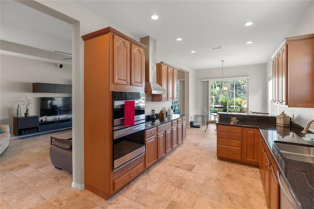 kitchen featuring a sink, appliances with stainless steel finishes, recessed lighting, wall chimney exhaust hood, and open floor plan