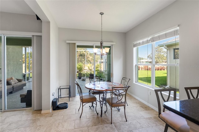 dining room featuring a chandelier and baseboards