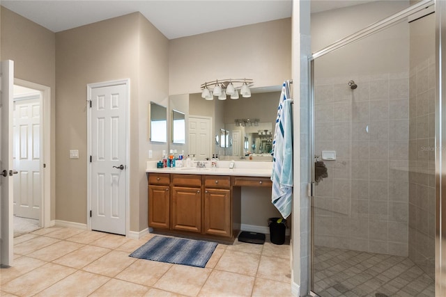 bathroom with a stall shower, tile patterned flooring, vanity, and baseboards