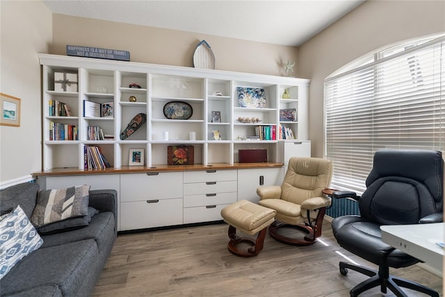 sitting room with light wood finished floors and a desk