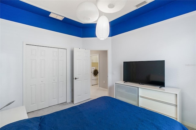 unfurnished bedroom featuring washer / dryer, carpet flooring, and a closet