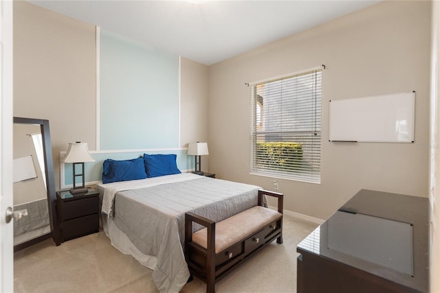 bedroom featuring light carpet and baseboards