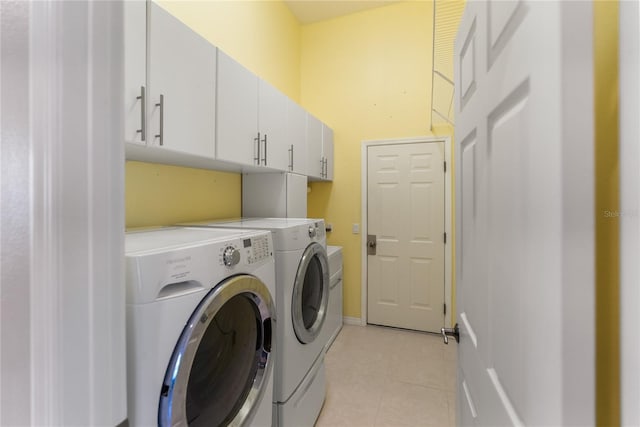 clothes washing area with independent washer and dryer, cabinet space, and light tile patterned floors