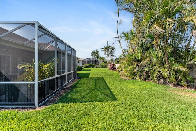 view of green lawn featuring a lanai