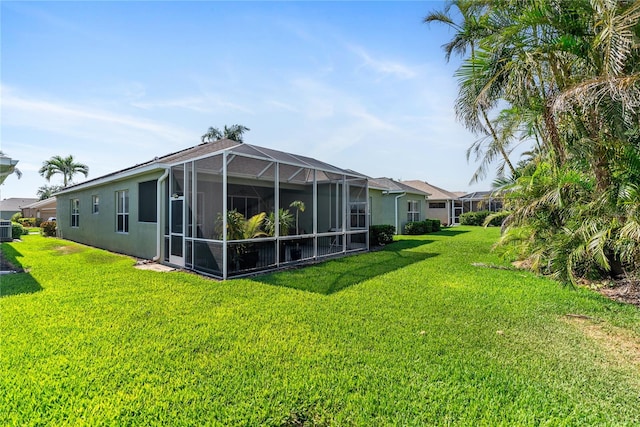 back of house with a yard, stucco siding, central AC unit, and glass enclosure