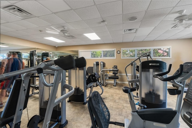 gym with a drop ceiling and baseboards