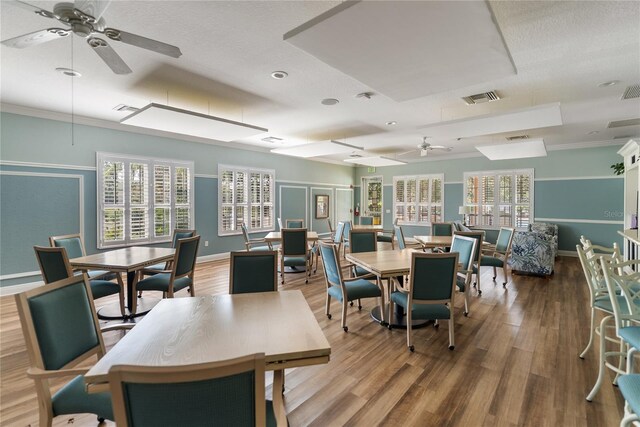dining space featuring a ceiling fan, wood finished floors, baseboards, and ornamental molding