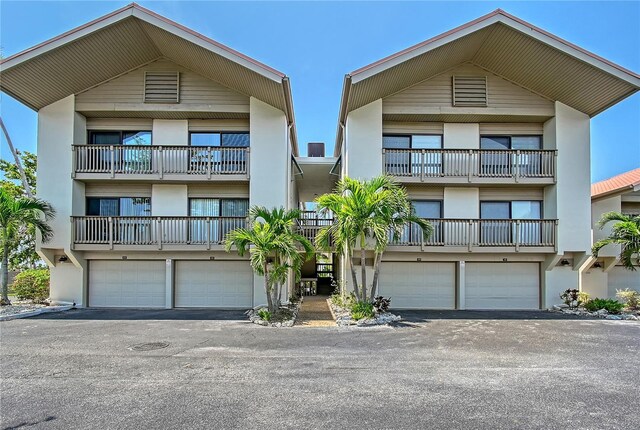 1159 Lake House Cir Unit C120, Sarasota, FL 34242 - view of front of property featuring stucco siding, an attached garage, and asphalt driveway