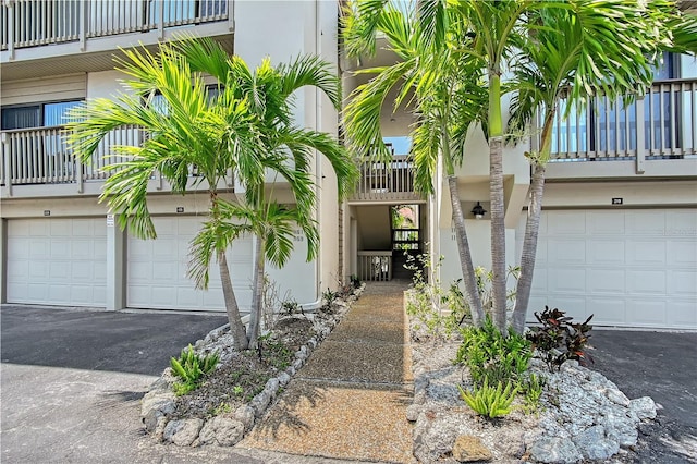 1159 Lake House Cir Unit C120, Sarasota, FL 34242 - doorway to property featuring a balcony, an attached garage, and stucco siding