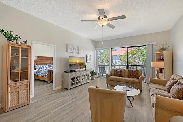 1159 Lake House Cir Unit C120, Sarasota, FL 34242 - living room featuring a textured ceiling, a ceiling fan, light wood-style floors, and baseboards