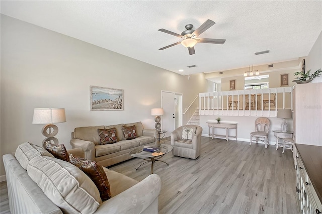 1159 Lake House Cir Unit C120, Sarasota, FL 34242 - living room with light wood finished floors, a ceiling fan, stairs, baseboards, and a textured ceiling