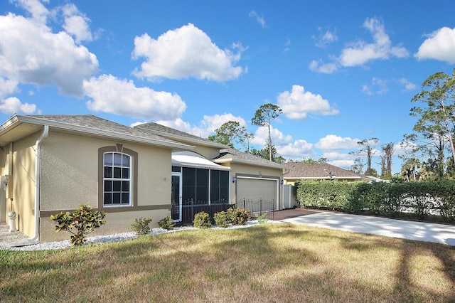 view of front facade with an attached garage, driveway, stucco siding, a front yard, and a shingled roof