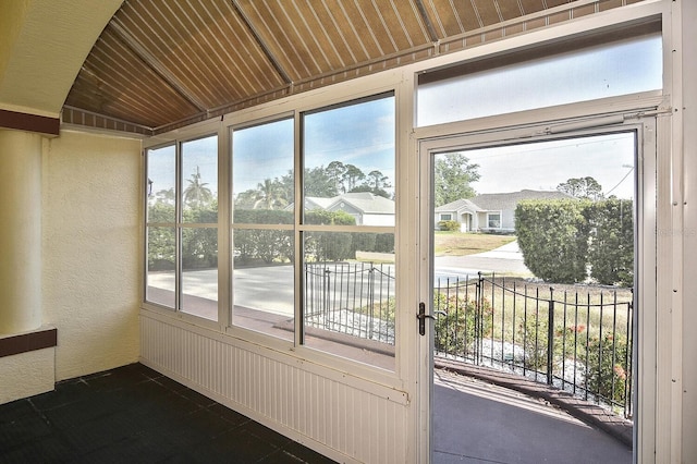 unfurnished sunroom featuring plenty of natural light and a textured wall