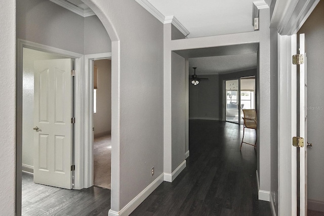 hall featuring arched walkways, ornamental molding, dark wood finished floors, and baseboards