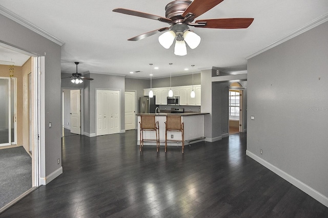 kitchen with crown molding, appliances with stainless steel finishes, baseboards, and ceiling fan