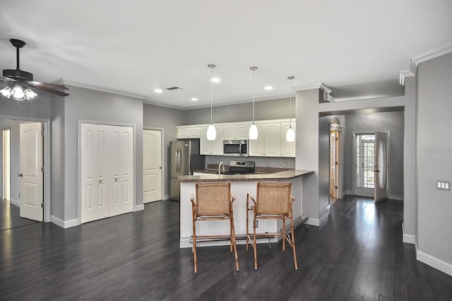kitchen featuring baseboards, ceiling fan, a peninsula, crown molding, and stainless steel appliances