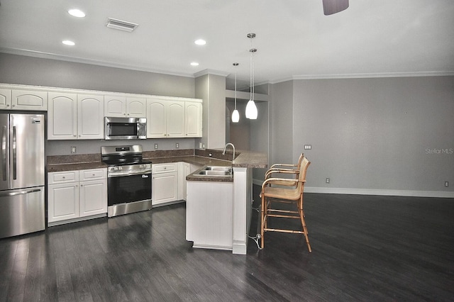 kitchen with a sink, a peninsula, ornamental molding, visible vents, and appliances with stainless steel finishes