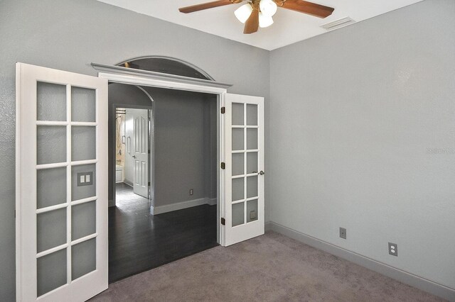 carpeted empty room with french doors, visible vents, baseboards, and ceiling fan