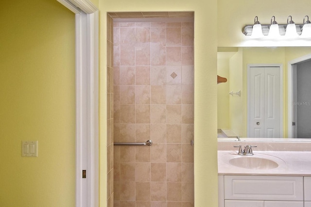 bathroom featuring tiled shower and vanity