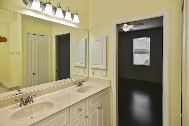 full bathroom featuring a ceiling fan, a closet, double vanity, and a sink