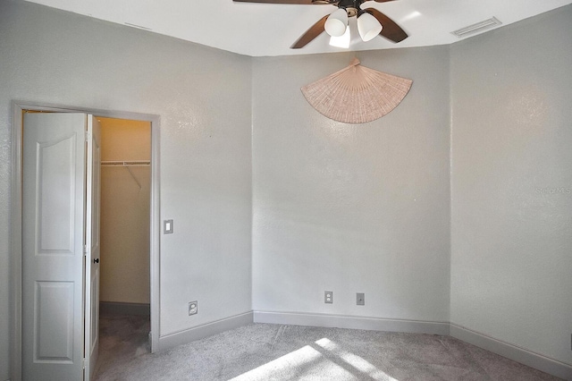 unfurnished bedroom with baseboards, a spacious closet, visible vents, and carpet