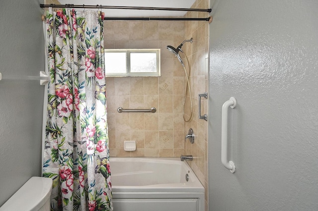 full bath featuring toilet, shower / bath combo with shower curtain, and a textured wall