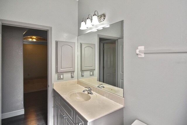 bathroom featuring vanity, baseboards, and wood finished floors