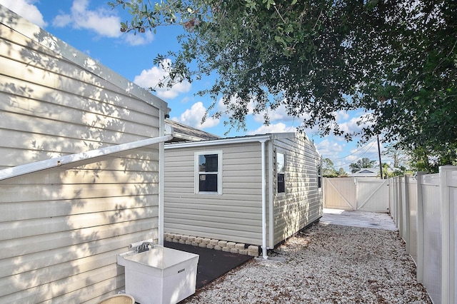 view of side of home featuring a gate and fence