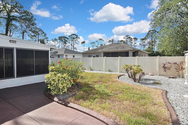 view of yard featuring a patio, a sunroom, and fence