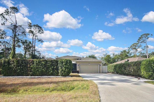 prairie-style home with concrete driveway, stucco siding, an attached garage, and fence