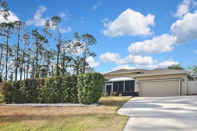 view of front of home featuring driveway, stucco siding, an attached garage, and a front yard