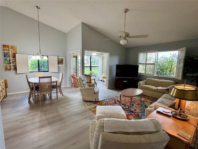 living area featuring a textured ceiling, high vaulted ceiling, ceiling fan, baseboards, and light wood-style floors