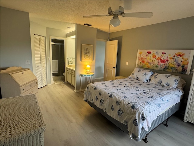 bedroom featuring light wood-style floors, connected bathroom, a ceiling fan, a closet, and baseboards