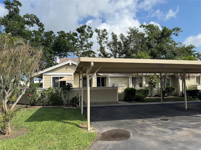 view of front of house featuring covered parking and a front yard