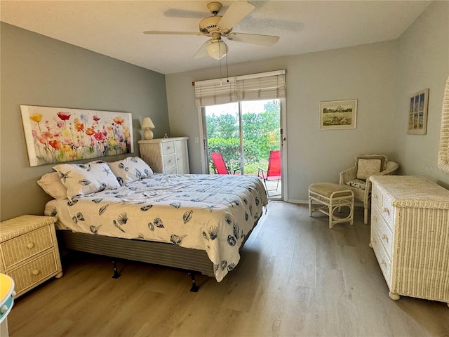 bedroom with access to outside, wood finished floors, ceiling fan, and baseboards