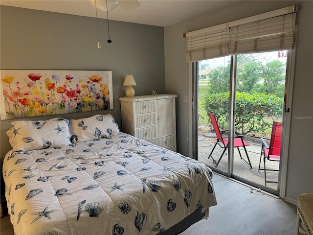 bedroom with access to outside and wood finished floors