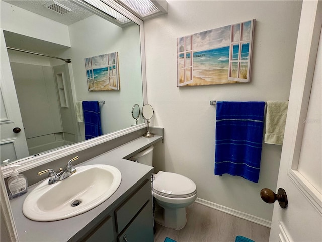 full bath with toilet, wood finished floors, visible vents, baseboards, and vanity