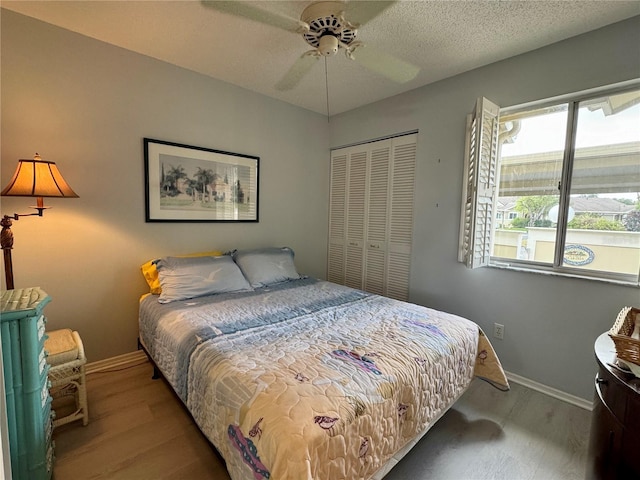 bedroom with a closet, baseboards, a ceiling fan, and wood finished floors