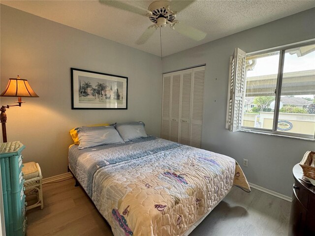 3002 Sail Pointe Cir Unit 1B, Venice, FL 34293 - bedroom featuring a closet, baseboards, a ceiling fan, and wood finished floors