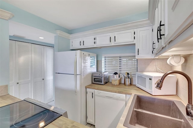 kitchen featuring a sink, white appliances, tasteful backsplash, white cabinetry, and light countertops