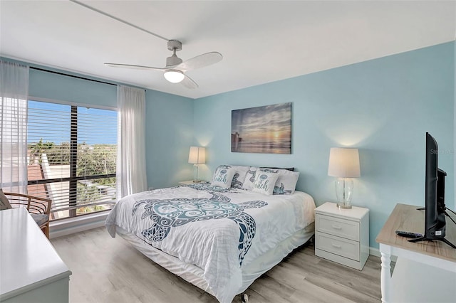 bedroom featuring baseboards, ceiling fan, and light wood-type flooring