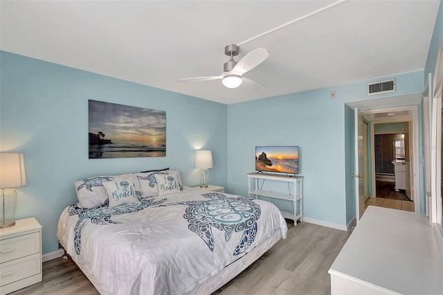 bedroom featuring baseboards, light wood-style floors, visible vents, and a ceiling fan